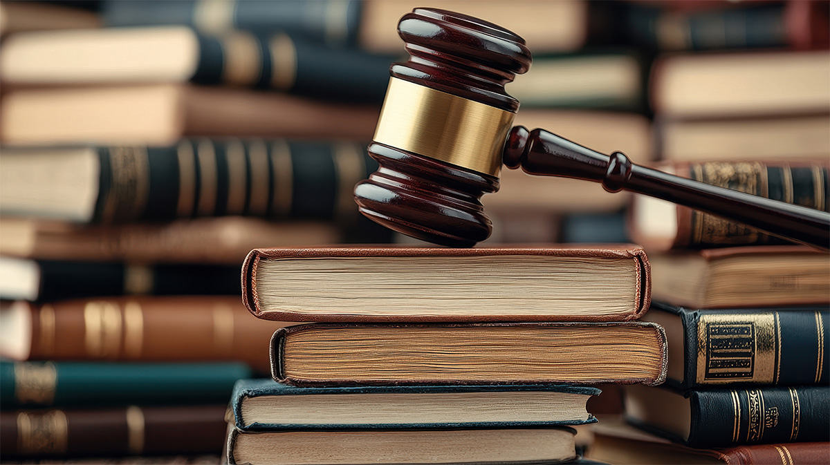 EU Cyber Resilience Act A brown gavel on a stack of books, with several more blured books in the background